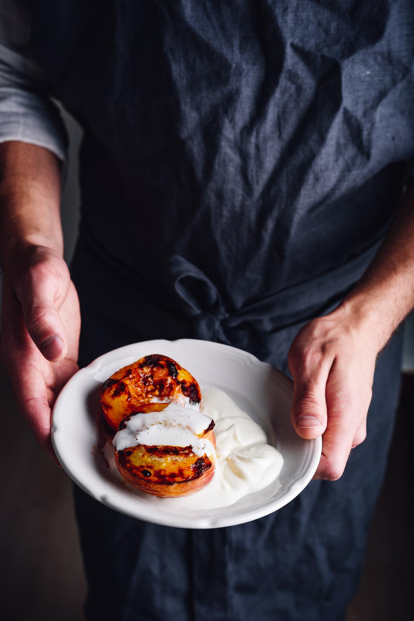 chef arranging plated dish in warm kitchen